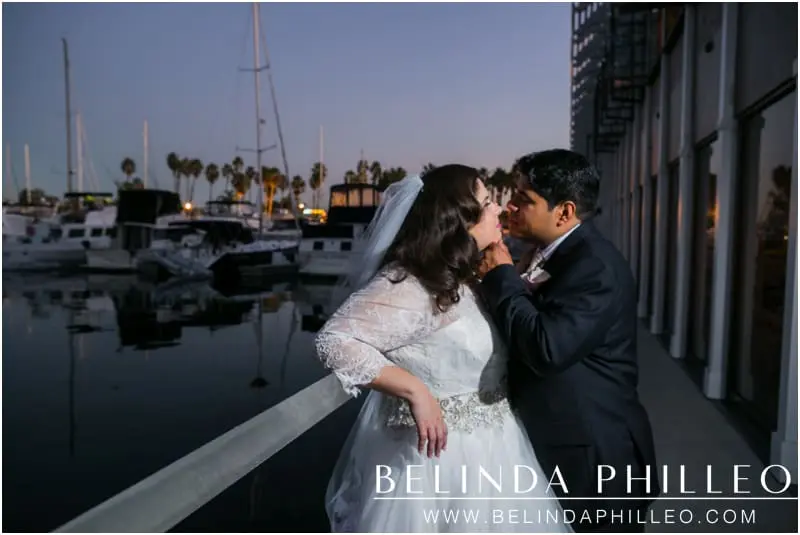Bride and groom share a kiss during a romantic sunset at The Portofino Hotel and Marina, Redondo Beach, CA