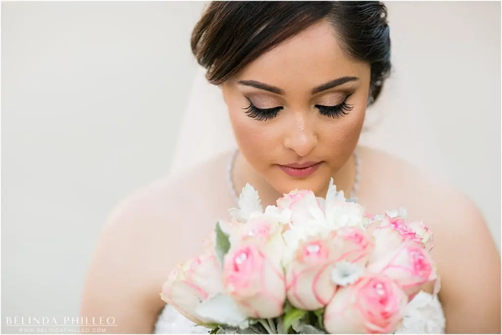 bride admires her pink and white bouquet