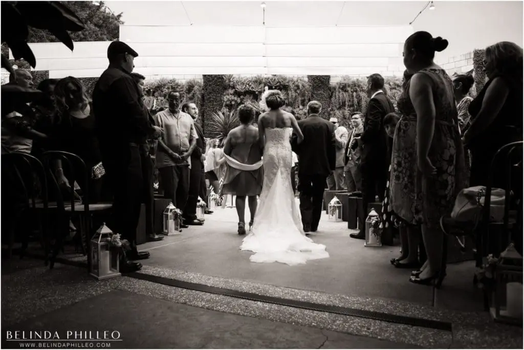 Bride walks down the aisle at Los Angeles Smog Shoppe wedding. Photo by Belinda Philleo