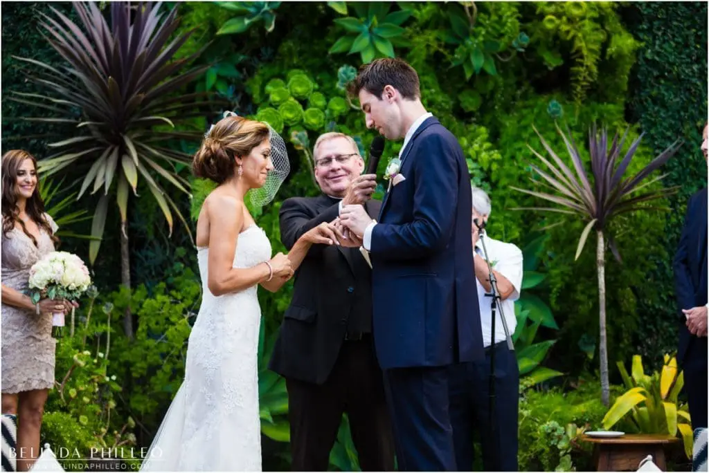 bride and groom exchange rings at Los Angeles Smog Shoppe wedding. Photography by Belinda Philleo