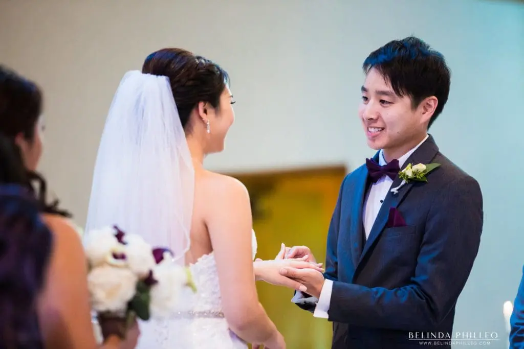 Bride and groom exchange rings at the San Gabriel Mission and church