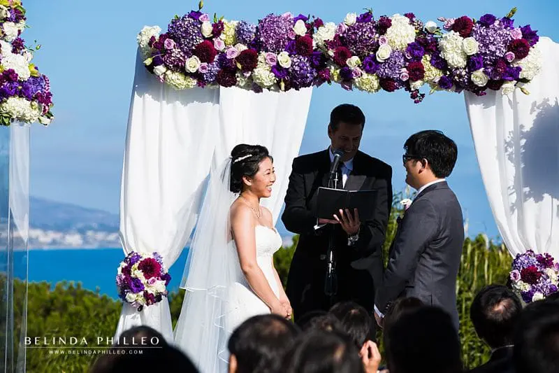 Purple and white flowers on ceremony arch at Laguna Cliffs Marriott Wedding in Dana Point, CA