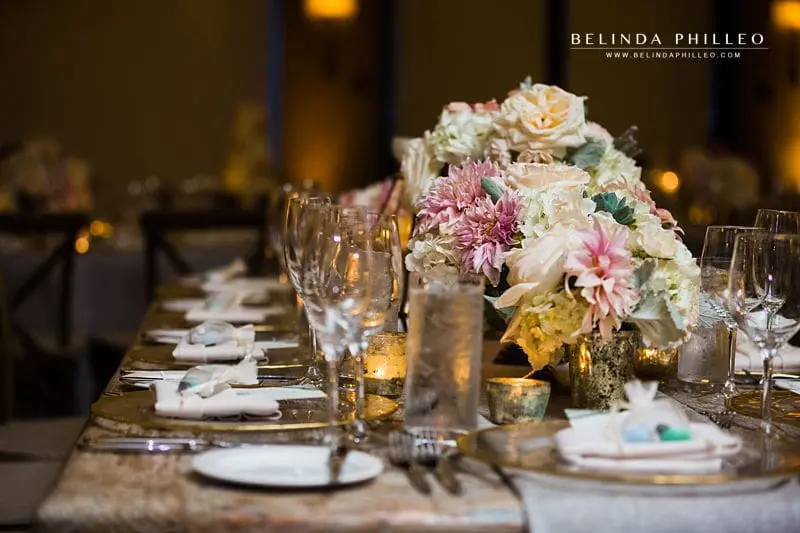 White and pink flowers adorn rustic tables for wedding reception at The Ranch Laguna