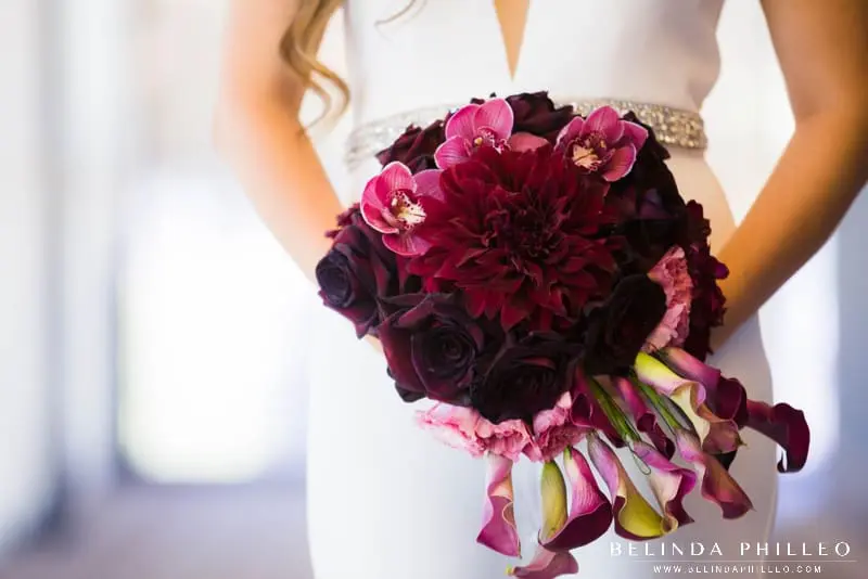 Modern Monochrome bridal bouquet made of merlot colored roses, lilies and orchids.