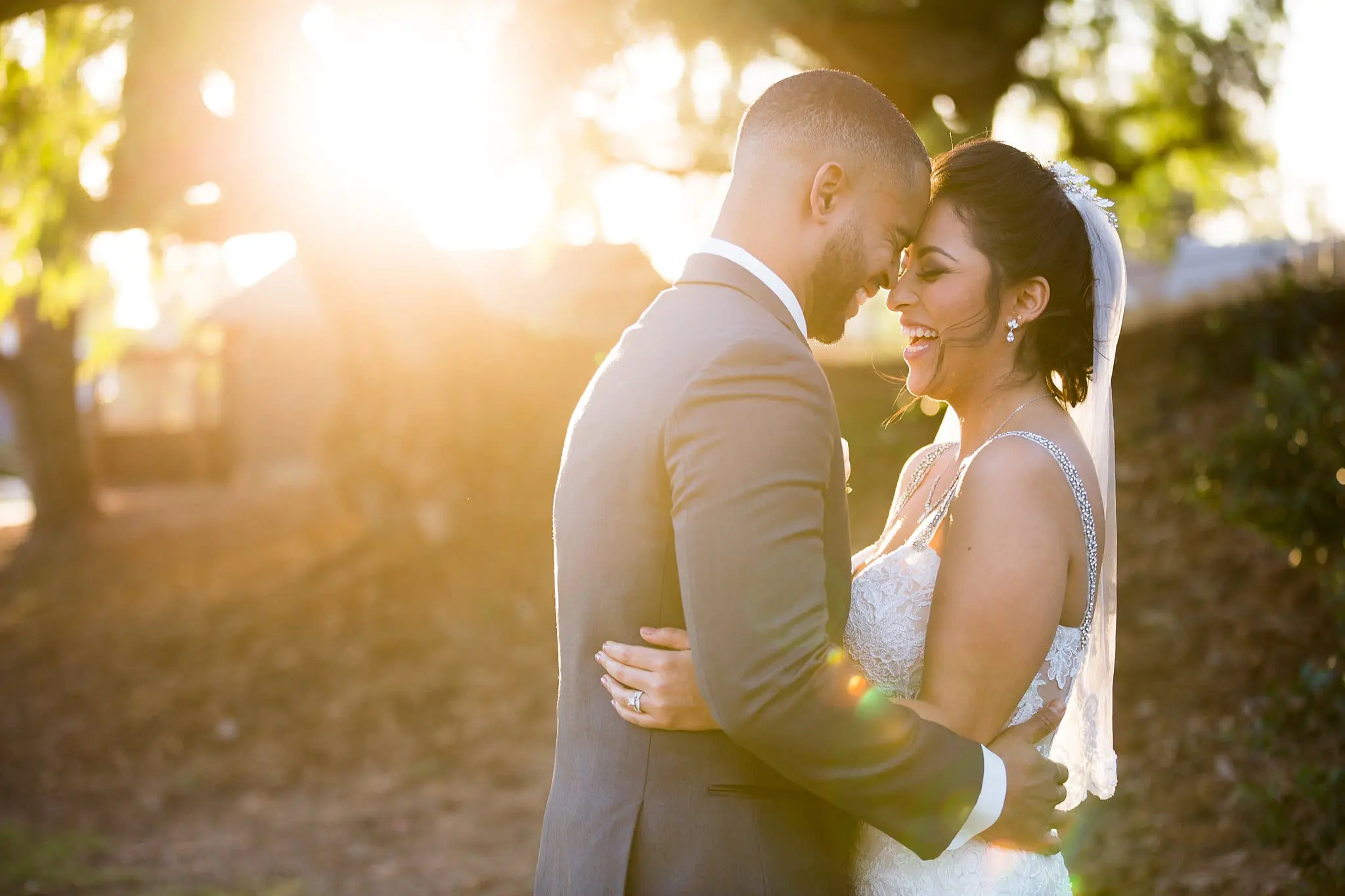 Bride and groom laugh candidly during their wedding portraits.