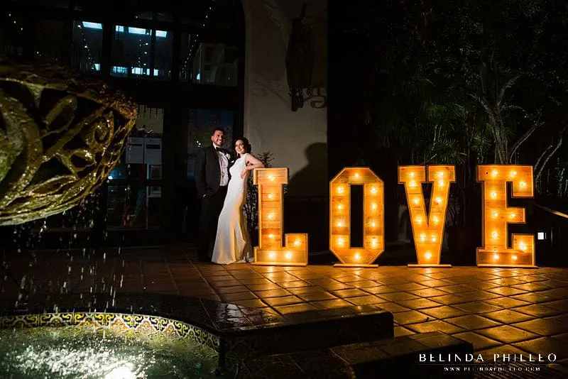 Bride and Groom pose next to Love Marquee at Los Angeles River Center and Gardens wedding