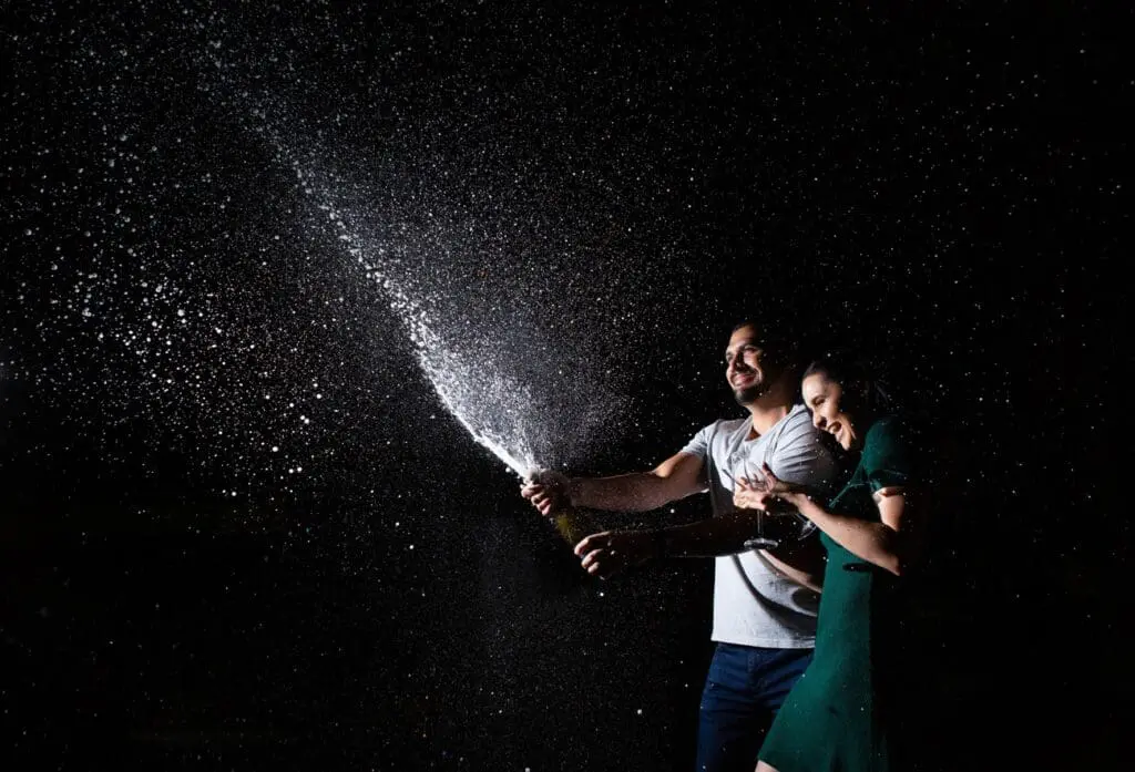 Couple sprays champagne during their session with Orange County Engagement Photographer Belinda Philleo