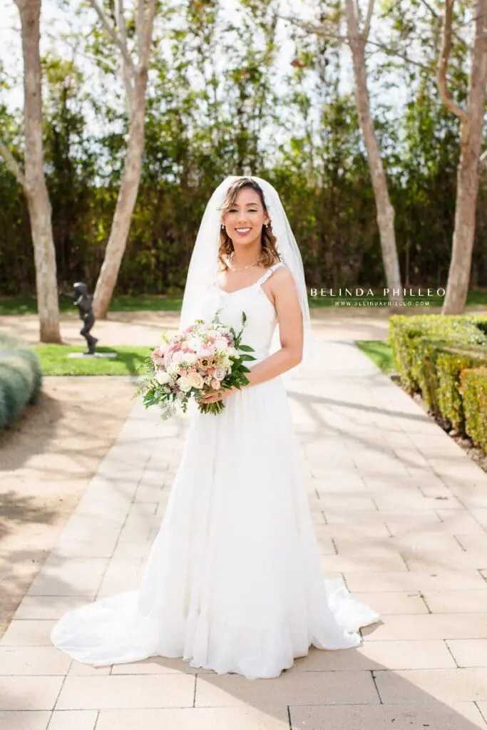 Bride in Justin Alexander wedding dress with pastel bridal bouquet of spring flowers