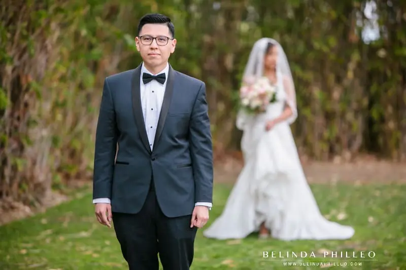 Groom in navy and black tux awaits the first look