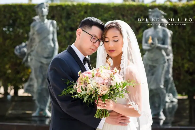 Wedding portraits in front of water fountain at Cerritos Sculpture Garden