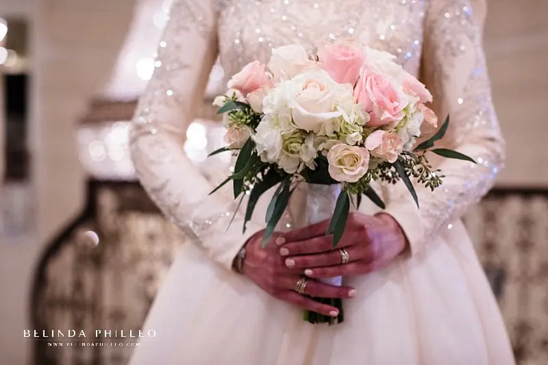 Bride shows off her white and blush bridal bouquet at the Brandview Ballroom in Glendale, CA. Photo by Belinda Philleo