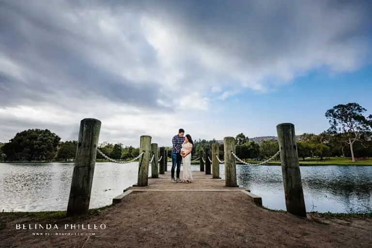 Maternity portrait on bridge with sweeping cloud sky
