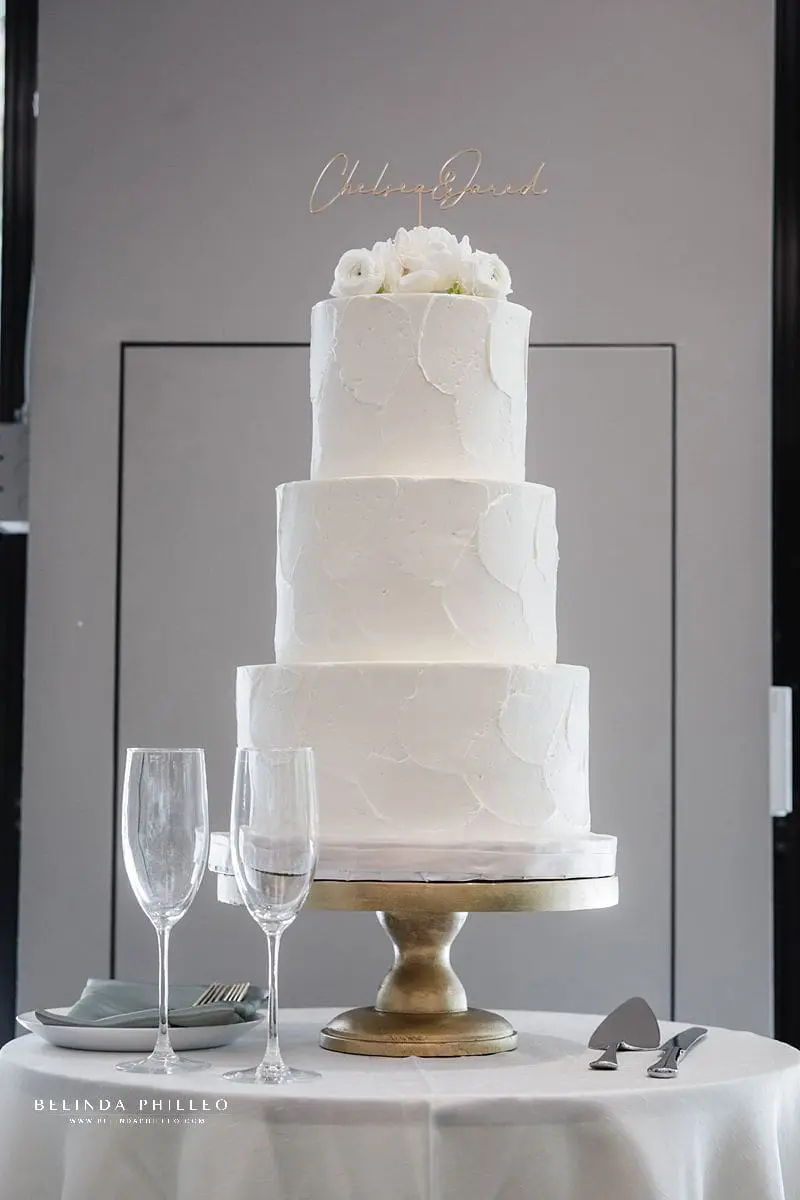 White wedding cake with gold topper