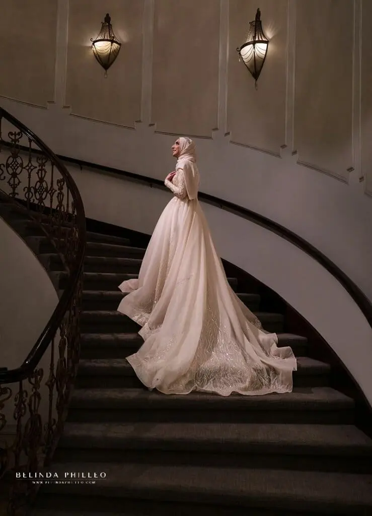 Bride waits for her groom on grand staircase during Brandview Ballroom wedding in Glendale, CA. Photo by Belinda Philleo