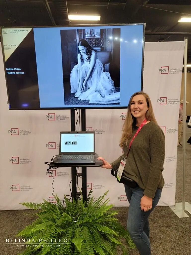 Photographer Belinda Philleo stands beside her Merit image "Finishing Touches" at the International Photographic Competition Exhibit Imaging USA in Nashville, TN. 2023