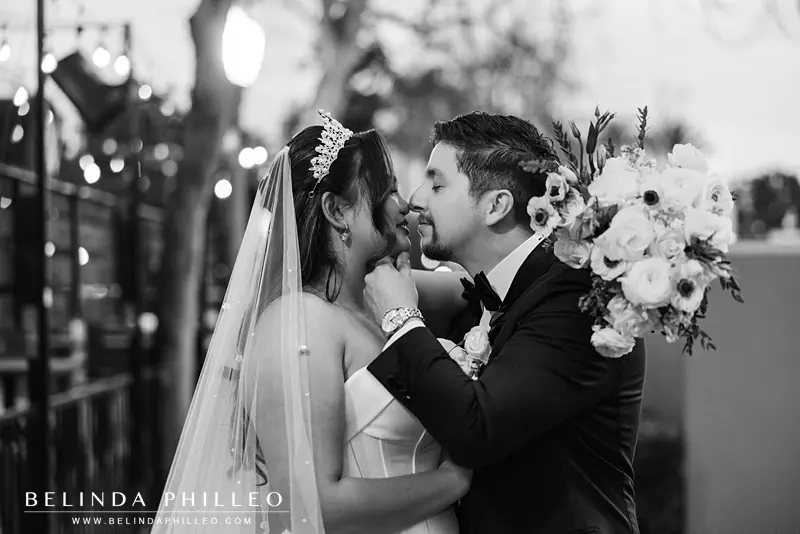 The groom pulls his bride in for a kiss with a soft hand under her chin
