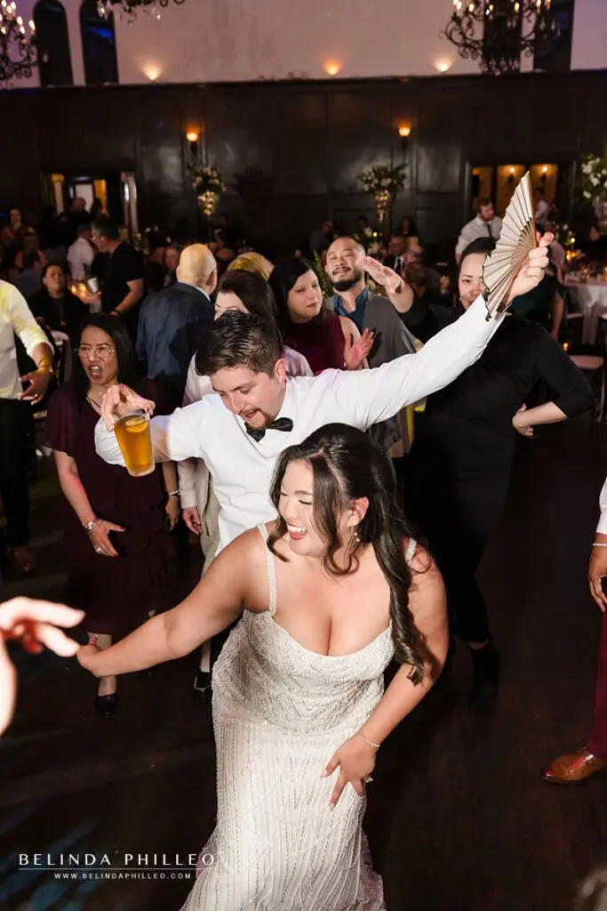 Bride and groom dance with their guests at the reception