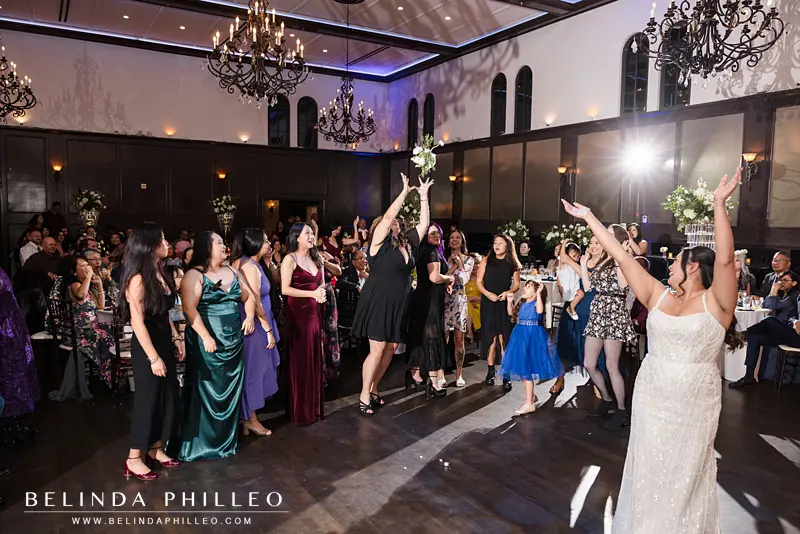 A wedding guest jumps to catch the bouquet after the bride threw it