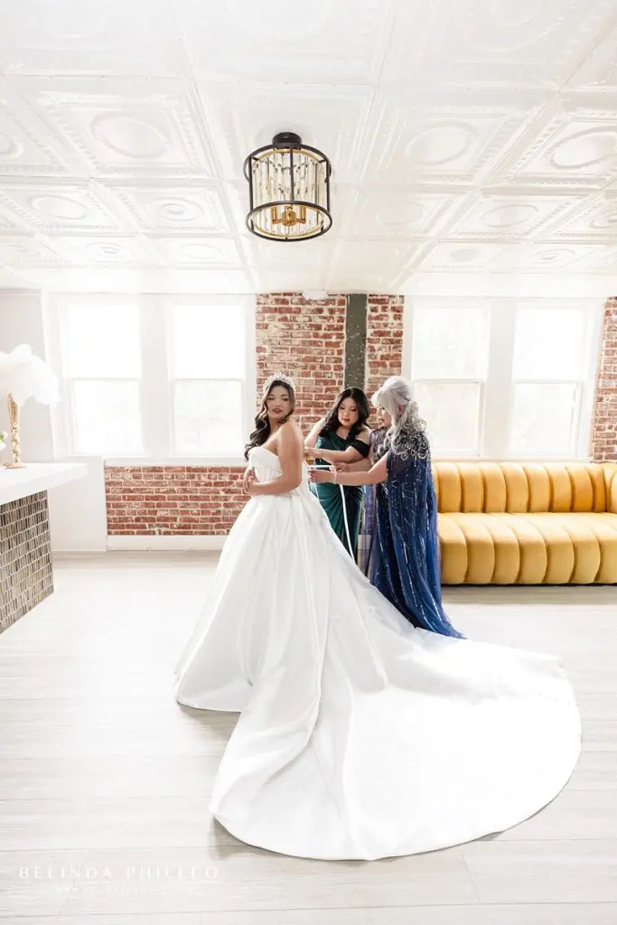 Bride's mother and sister help her get dressed in the bridal suite at The Charleston in Fullerton, CA