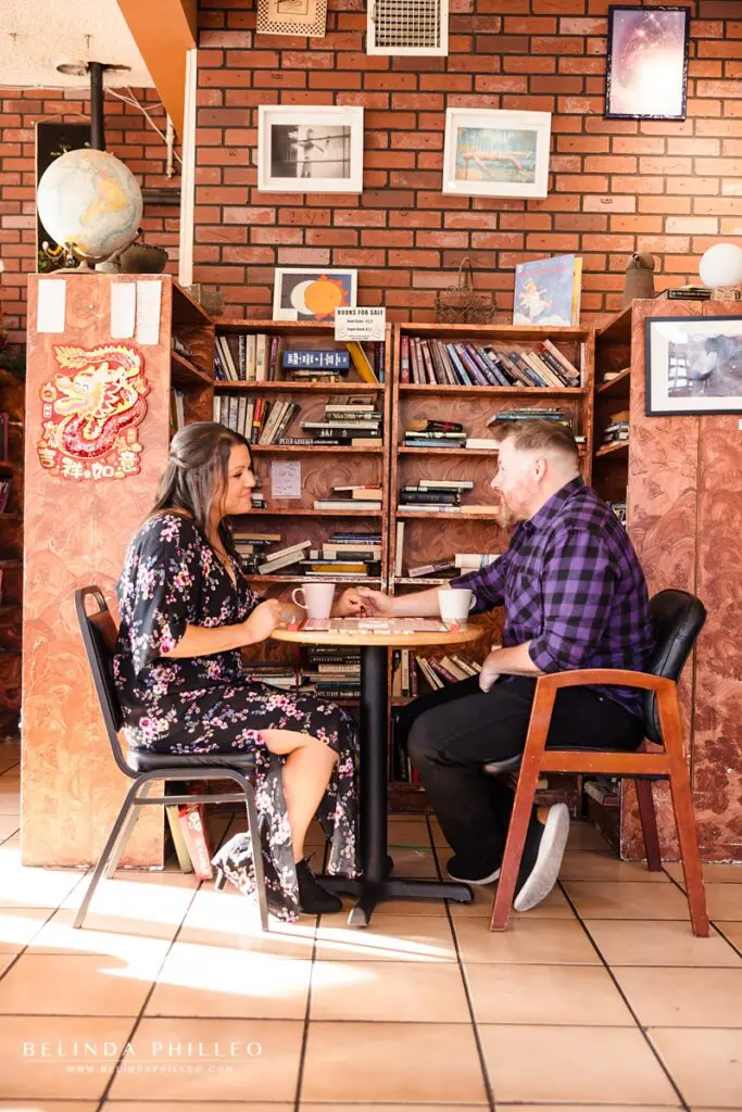 A couple plays scrabble in a coffee shop while enjoying their drinks