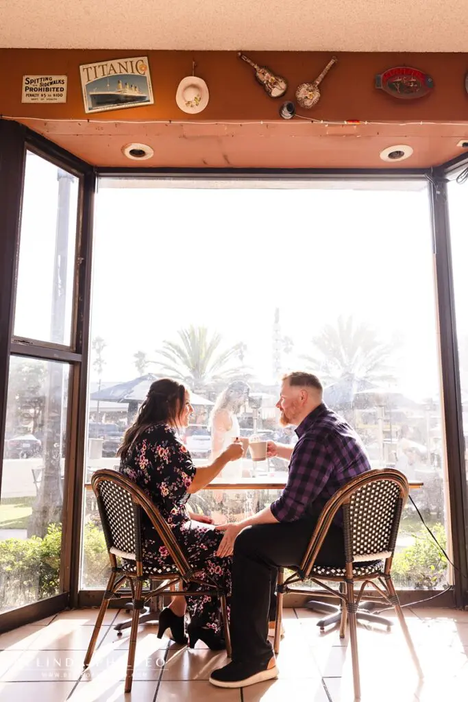 Engaged couple toasts with their coffee mugs at Coffee Cartel in Redondo Beach