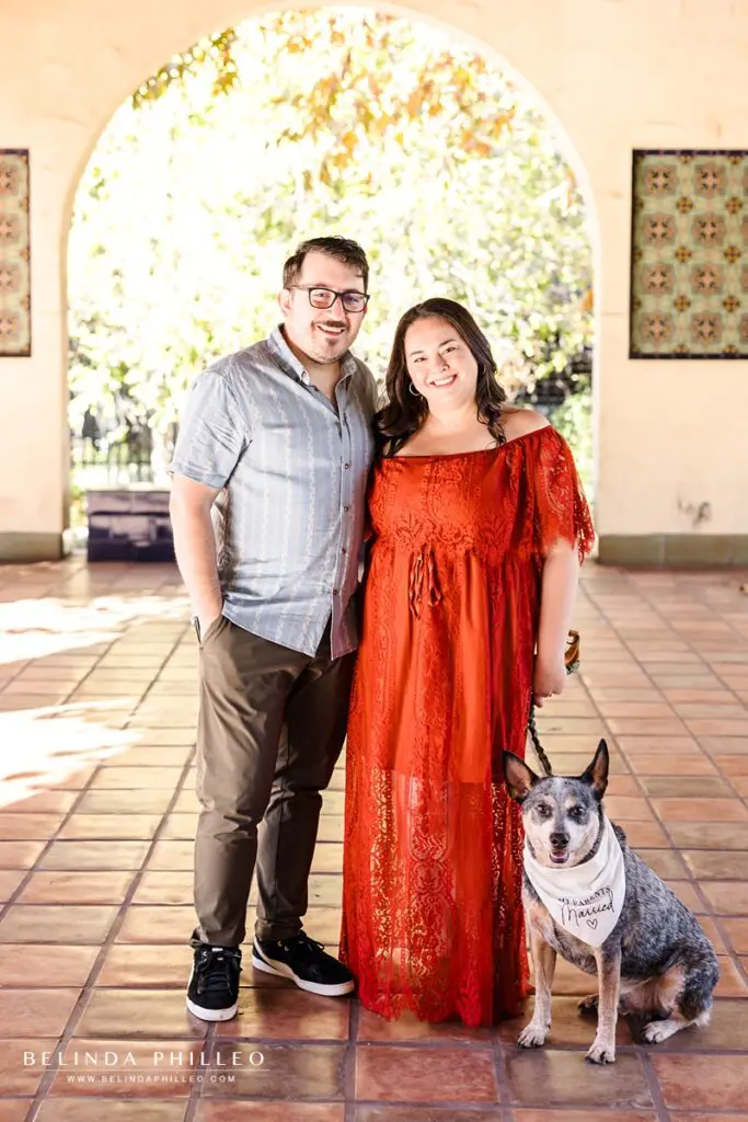 Engaged couple poses for a picture with their beloved dog