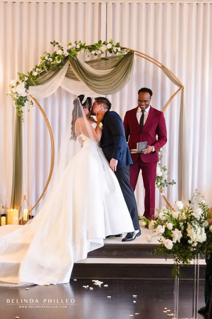 The bride and groom share their first kiss after the wedding ceremony