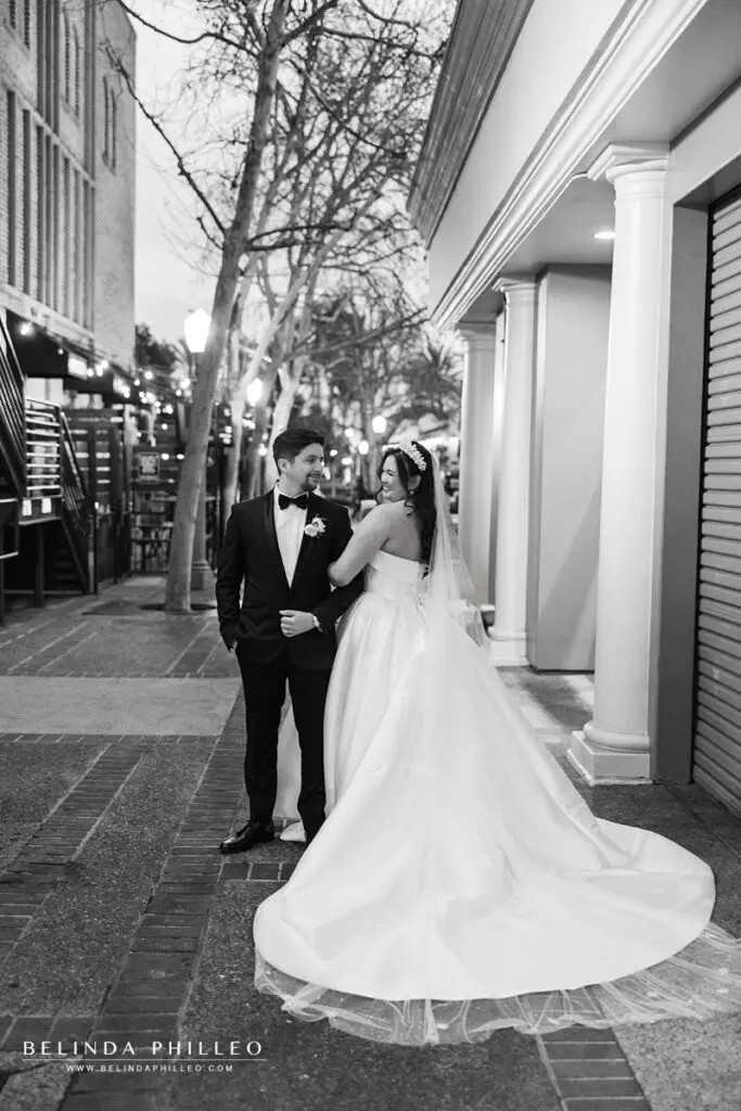 The bride and groom smile at eachother outside their wedding venue