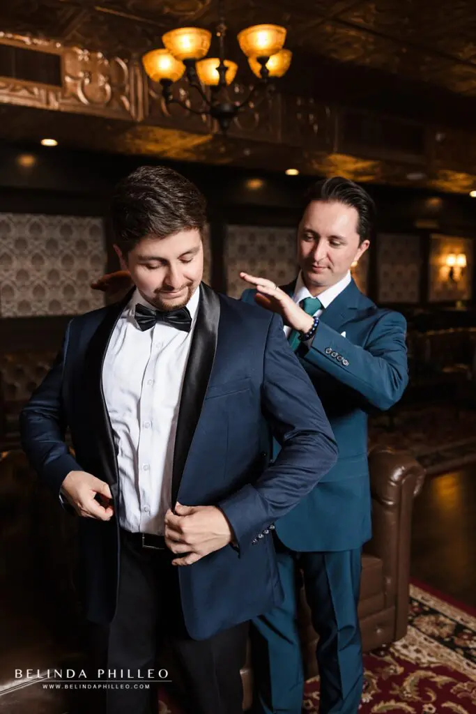 A groom buttoning up his jacket before the ceremony at his Charleston Venue wedding in Fullerton, CA