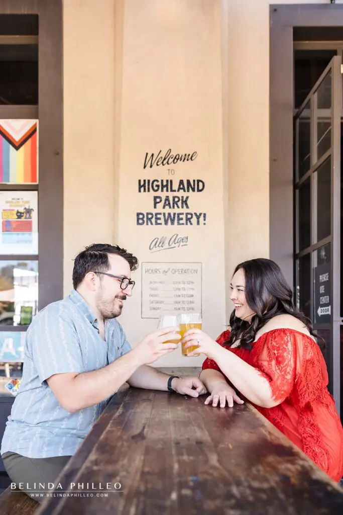 Engaged couple toast with their beers at Higland Park Brewery