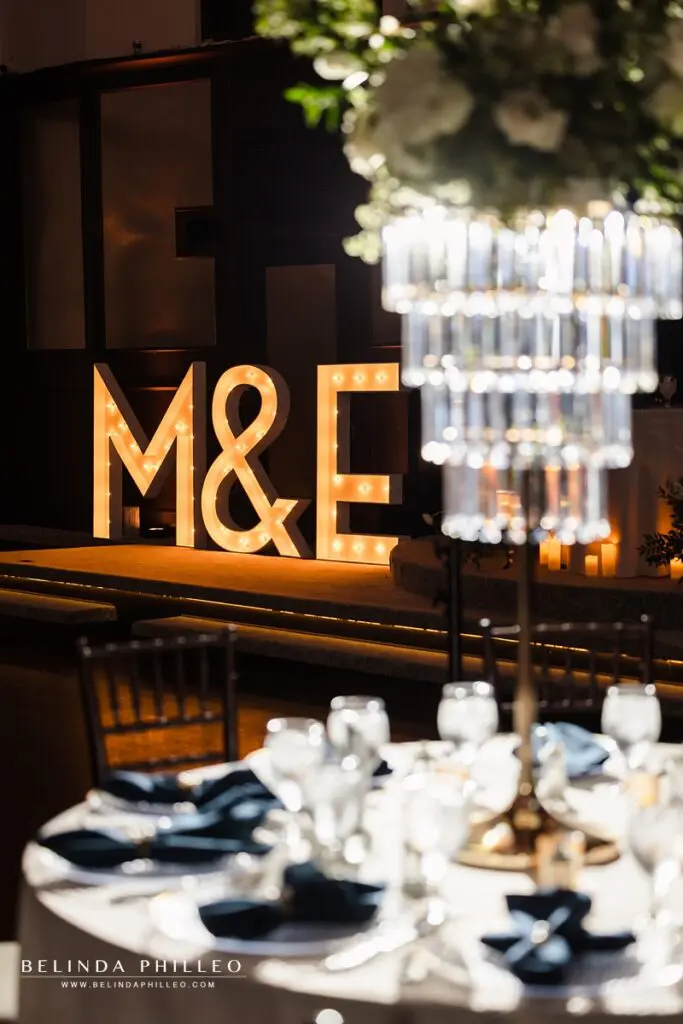 Giant Marquee letters framed by a chandelier centerpiece at a wedding reception