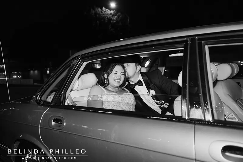 Bride and groom share a kiss in their getaway car at the end of the night
