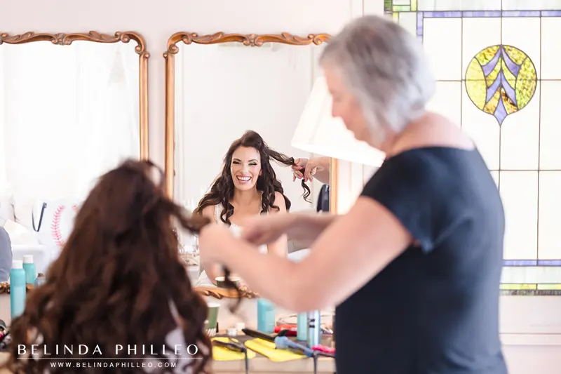 Bride getting her hair done in the dressing room before her wedding at The French Estate in Orange, CA