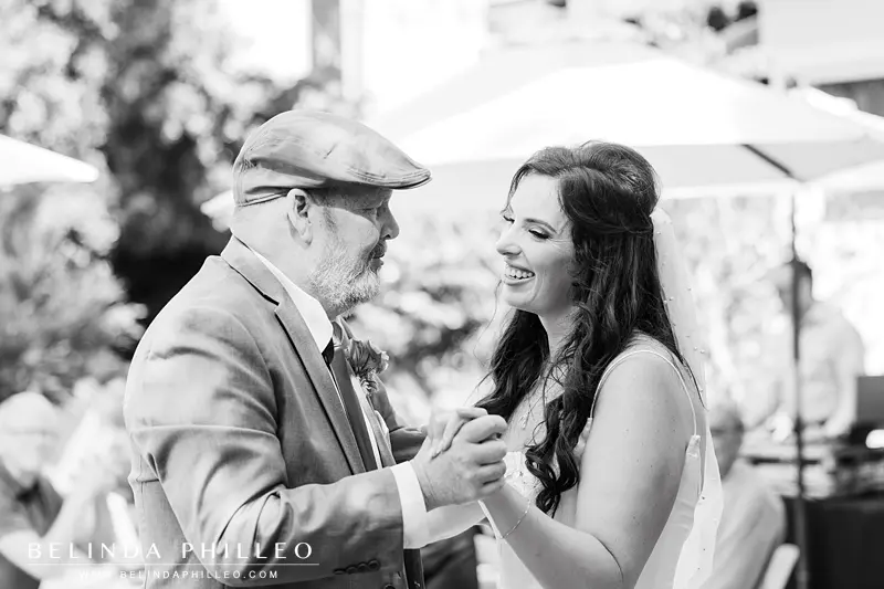 Closeup black and white image of a bride dancing with her father