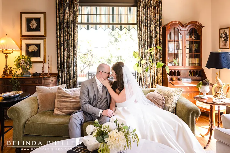 Newlyweds share a sweet moment on the couch at The French Estate during their wedding day