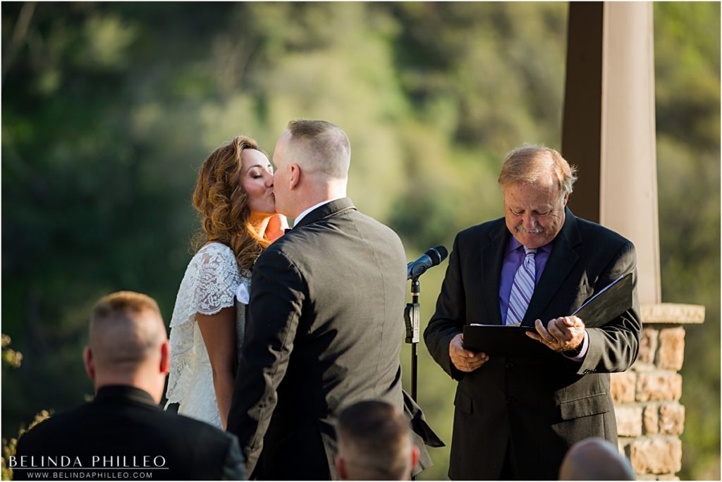 Newlyweds share a first kiss at their Serendipity Gardens wedding in Oak Glen, CA