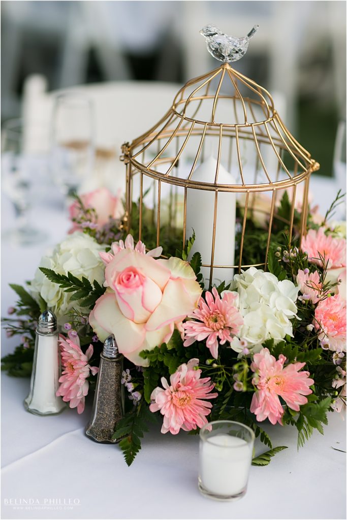 pink and white flowers surround a birdcage centerpiece at Kellogg House wedding reception, Cal Poly, CA