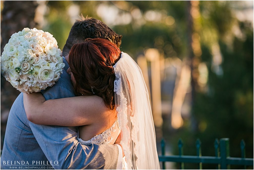 Bride and groom share an emotional hug moments after saying I do at the Reef Restaurant, Long Beach, CA