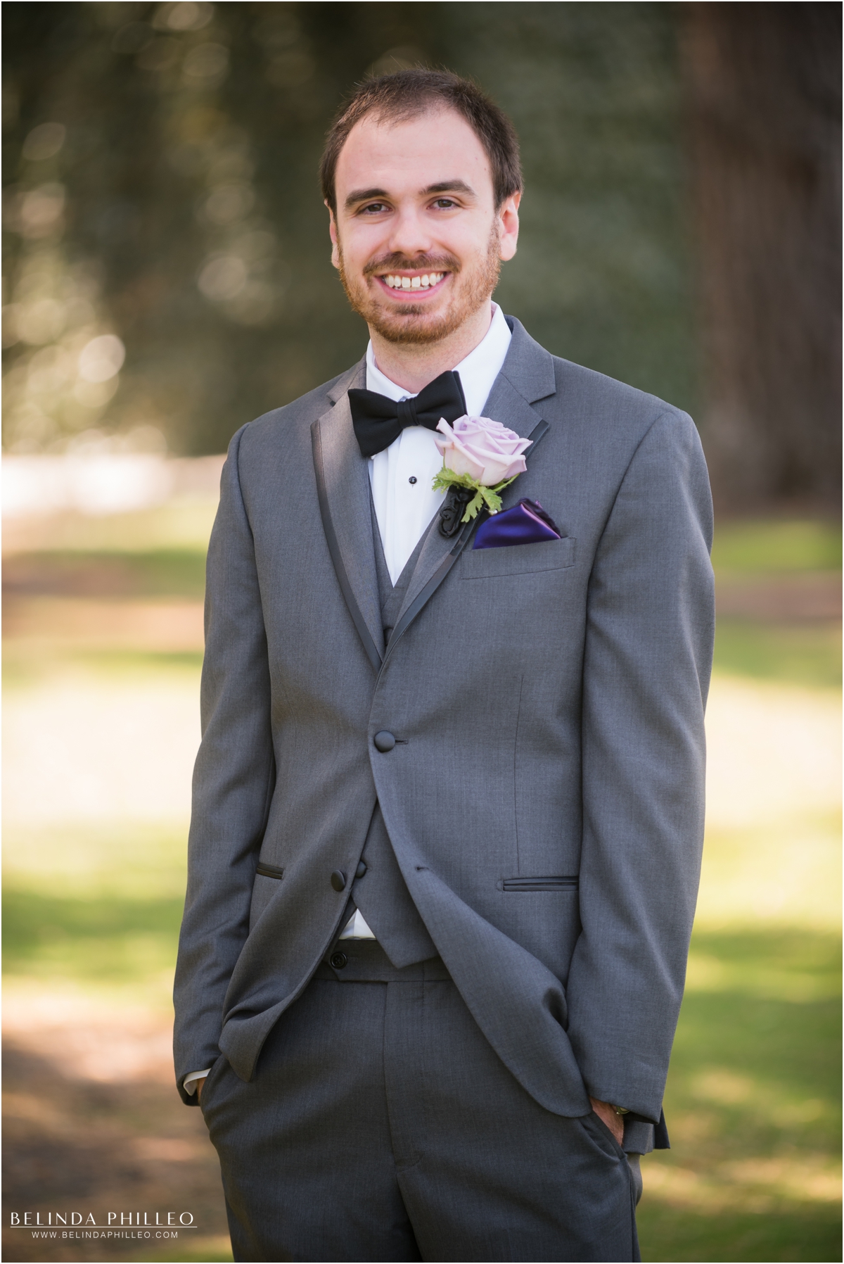 Grey groom's tux wit purple napkin square and lavender rose boutonnière at El Dorado Park Golf Course wedding