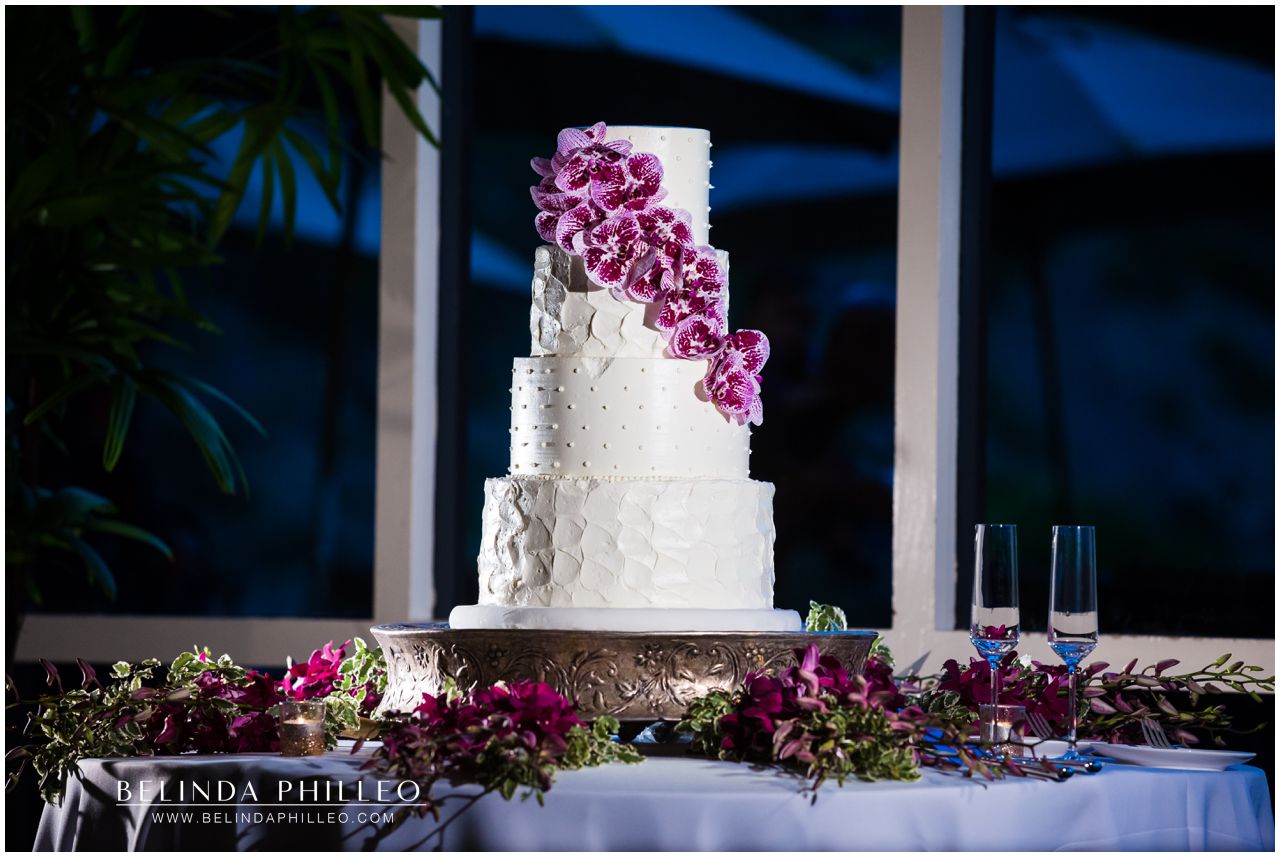 Purple orchids decorate a white wedding cake by Simply Irresistible Cakes at Friendly Hills Country Club Wedding