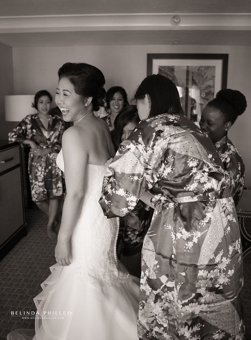 Bride is helped by her bridesmaids when getting ready for her Laguna Cliffs Marriott wedding in Dana Point, CA