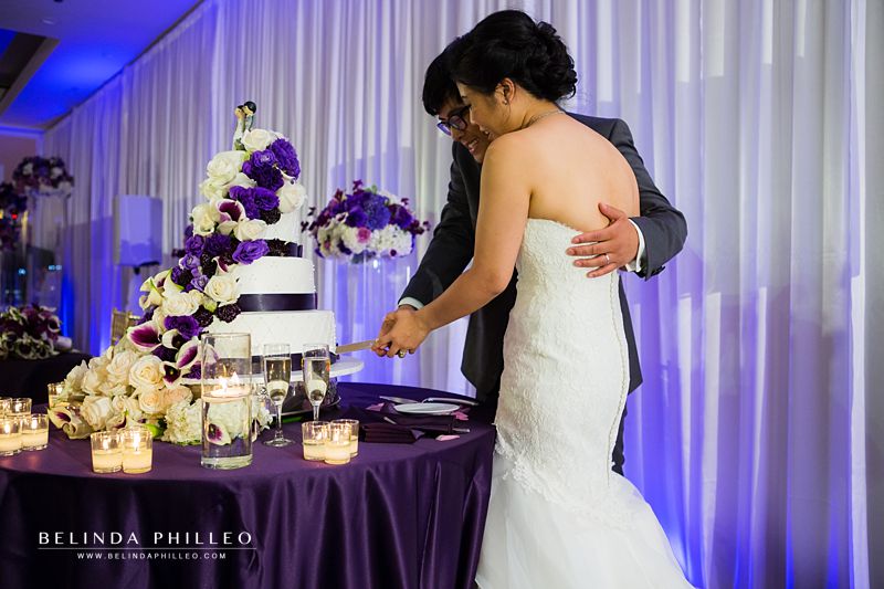 Newlyweds cut the cake at their purple Laguna Cliffs Marriott Wedding