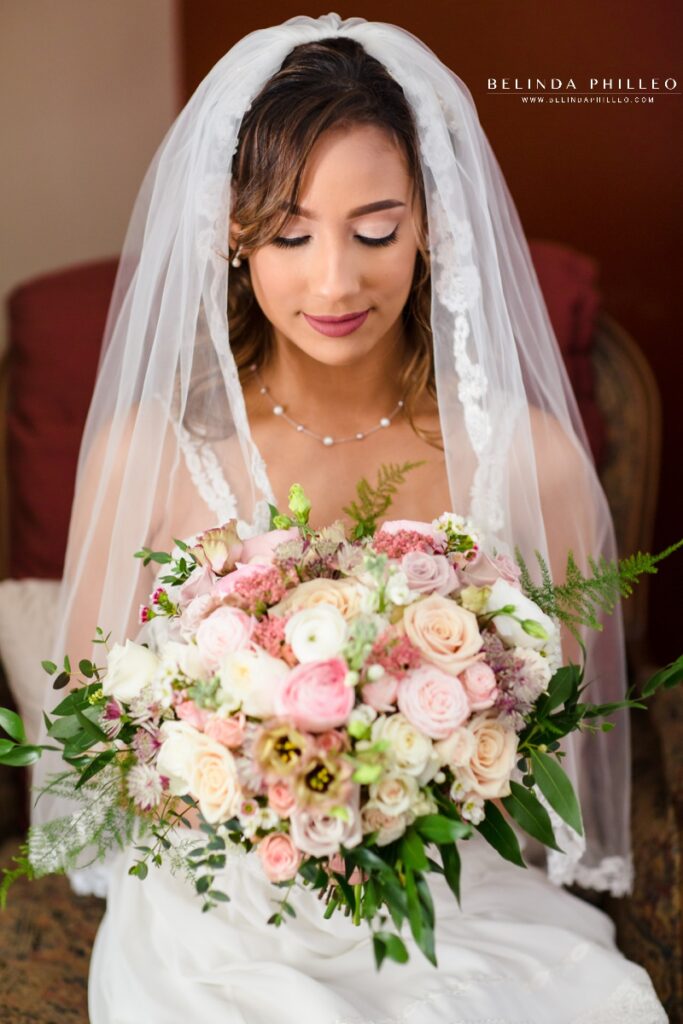Bride admires her pastel bridal bouquet from The Bloom of Time