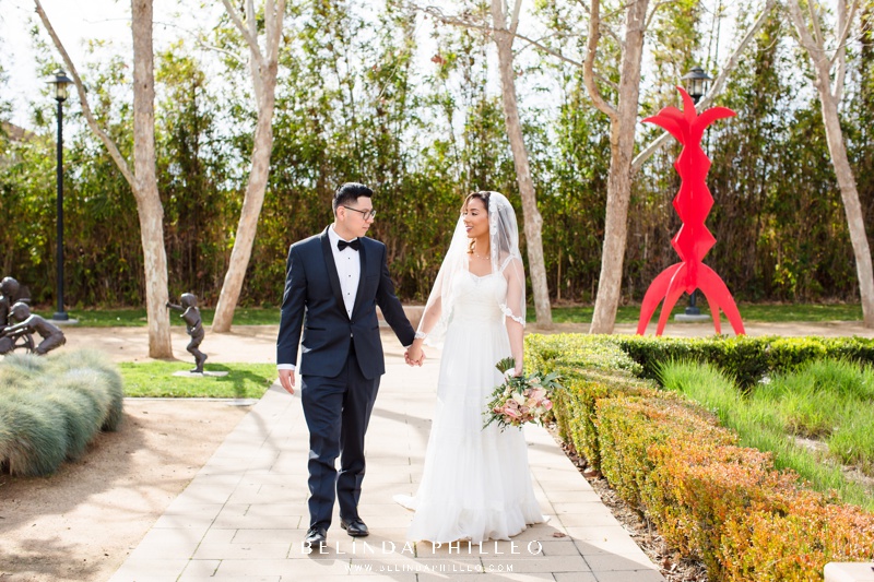 Bride and groom walking at Cerritos Sculpture Garden