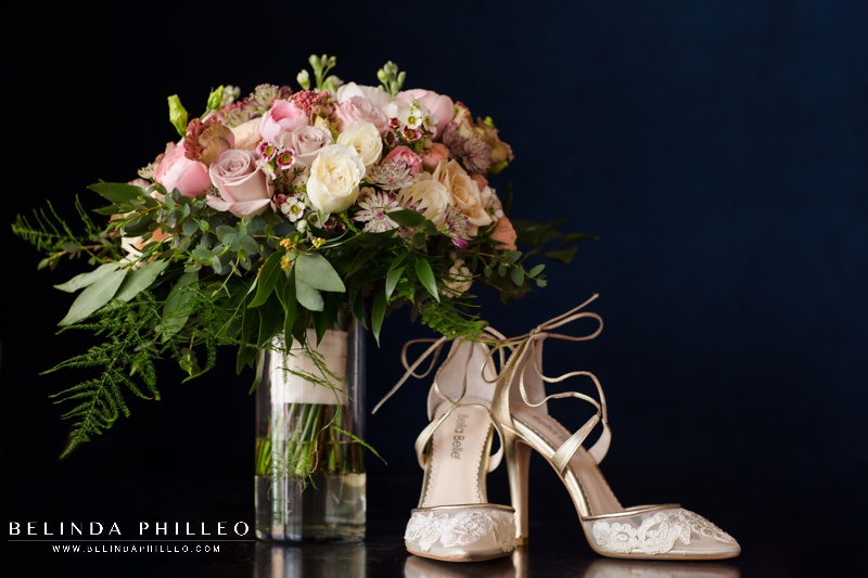 Spring bridal bouquet with white and lavender roses, and mauve and white ranunculus. Lace closed toed bridal shoes from Bella Belle