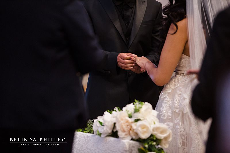 Groom places wedding ring on his bride's finger during wedding ceremony in California. Photo by Belinda Philleo