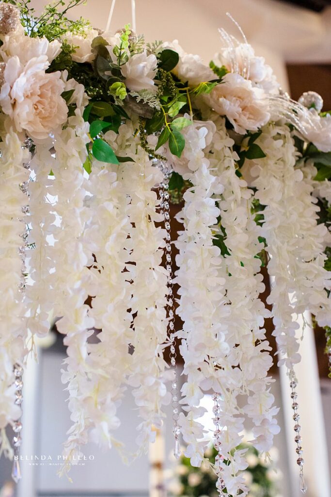 Close up of white floral wedding arch at wedding ceremony in Westmister, CA. Photo by Belinda Philleo.