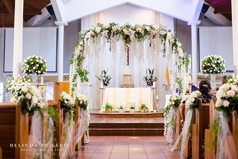 White floral arch on ceremony altar for a whimsical wedding in Westminster, CA. Photo by Belinda Philleo