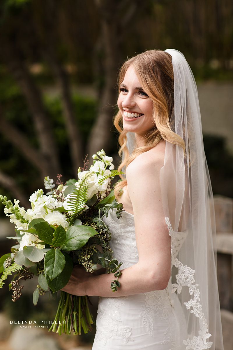 Glowing bride smiles at her groom before their garden wedding ceremony at JACCC in Los Angeles, CA