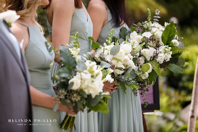 All white bridesmaid bouquets and sage green bridesmaid gowns from David's Bridal